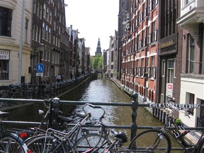 Canal with bicycles lining the sidewalk on the left side
