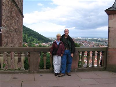 Fred and Kathy stand on a castle patio overlooking Heidelberg, with the river in the background
