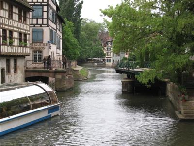 A lovely canal, with a touring boat passing through a drawbridge, having just cleared a lock